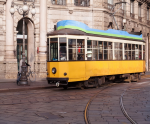 A yellow tram is riding down the street - F-287